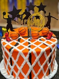 a basketball themed birthday cake with basketballs and basketball players on top